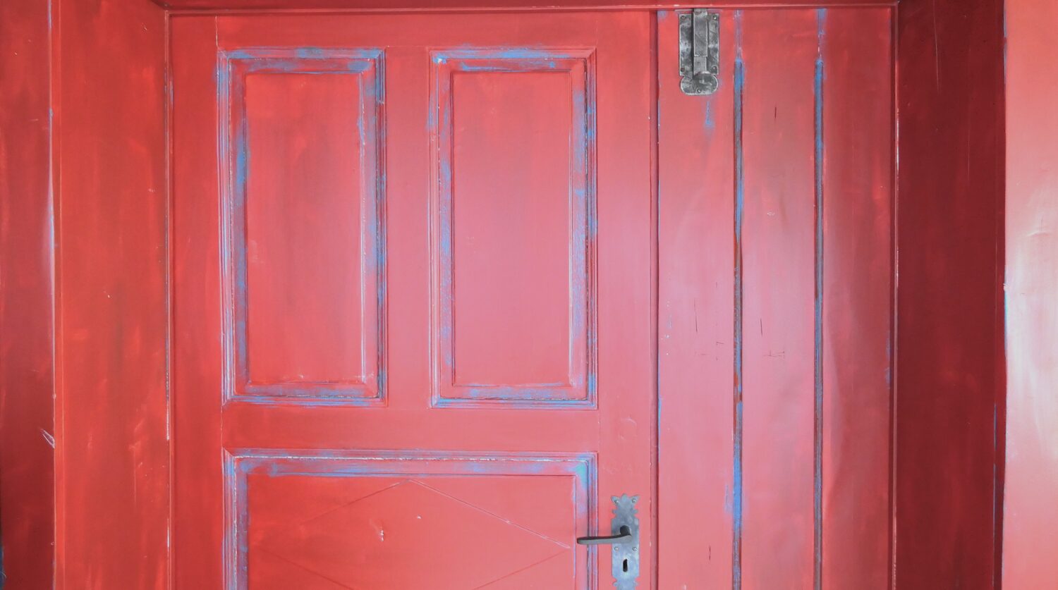 Rote Holztür mit sichtbarer Patina und klassischem Design im Vintage-Stil