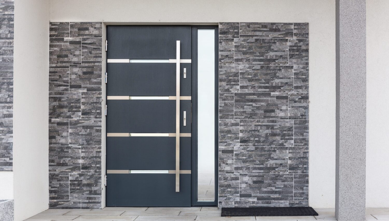 Zeitgemäße Haustür mit Glaselement und grauer Natursteinverkleidung
