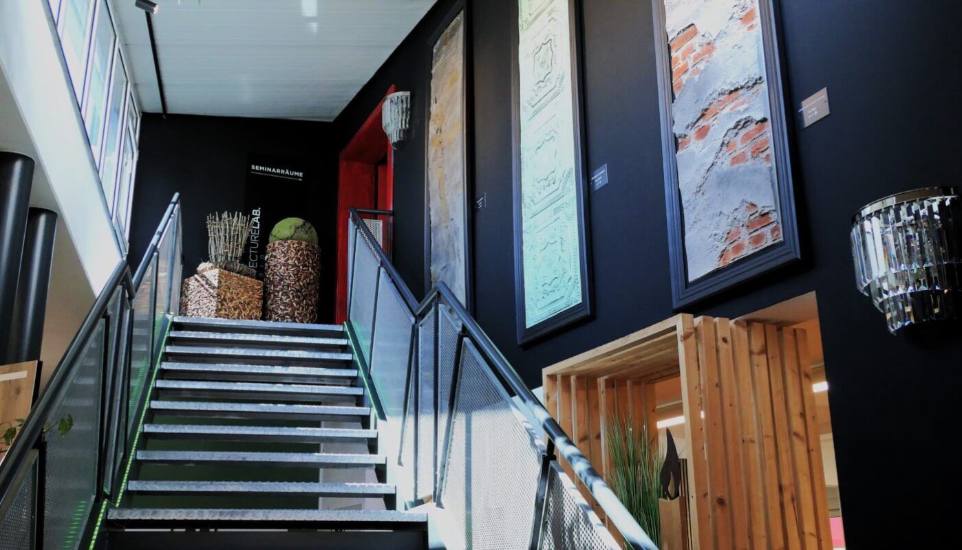 Innenausstellung bei Holz Hertel mit moderner Treppe und Wandgestaltung aus verschiedenen Materialien