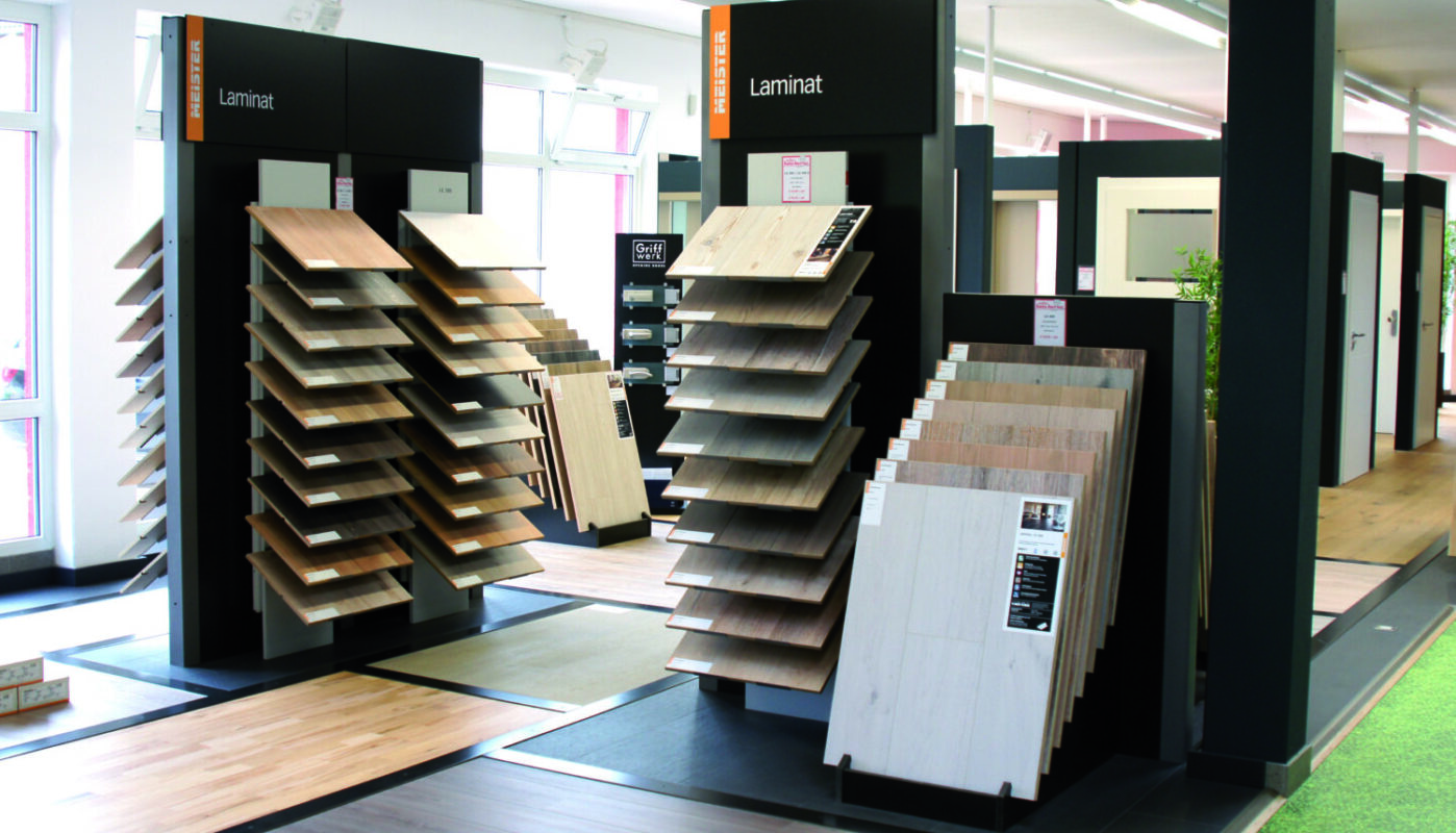Ausstellung von Laminatboden-Mustern bei Holz Hertel mit übersichtlicher Präsentation auf schwarzen Ständern
