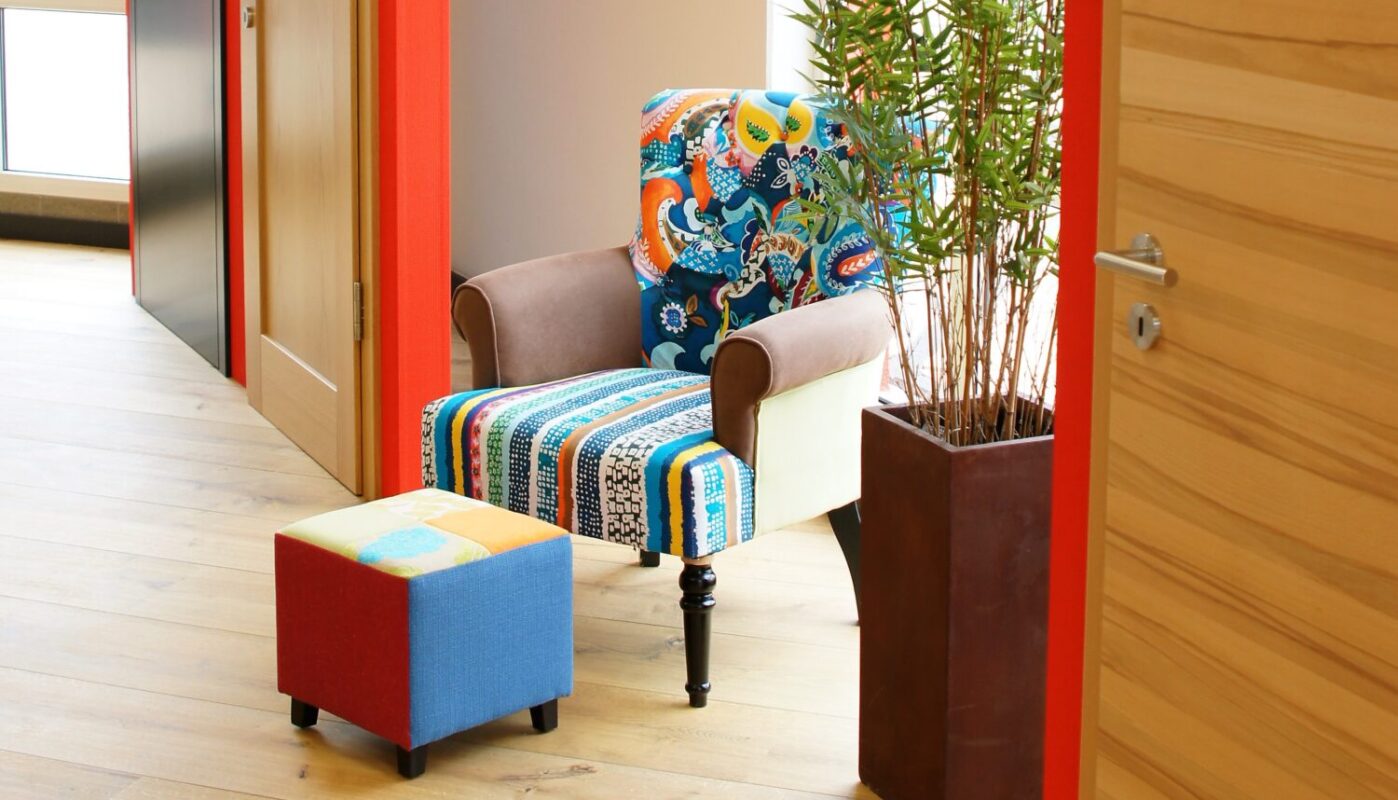 Bunte Sitzgelegenheit in einer modernen Ausstellung mit Türen, Holzfußboden und Pflanzen